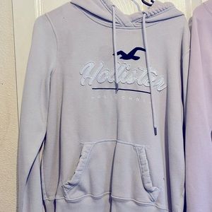 TWO Hollister hoodies one light purple and others light blue.